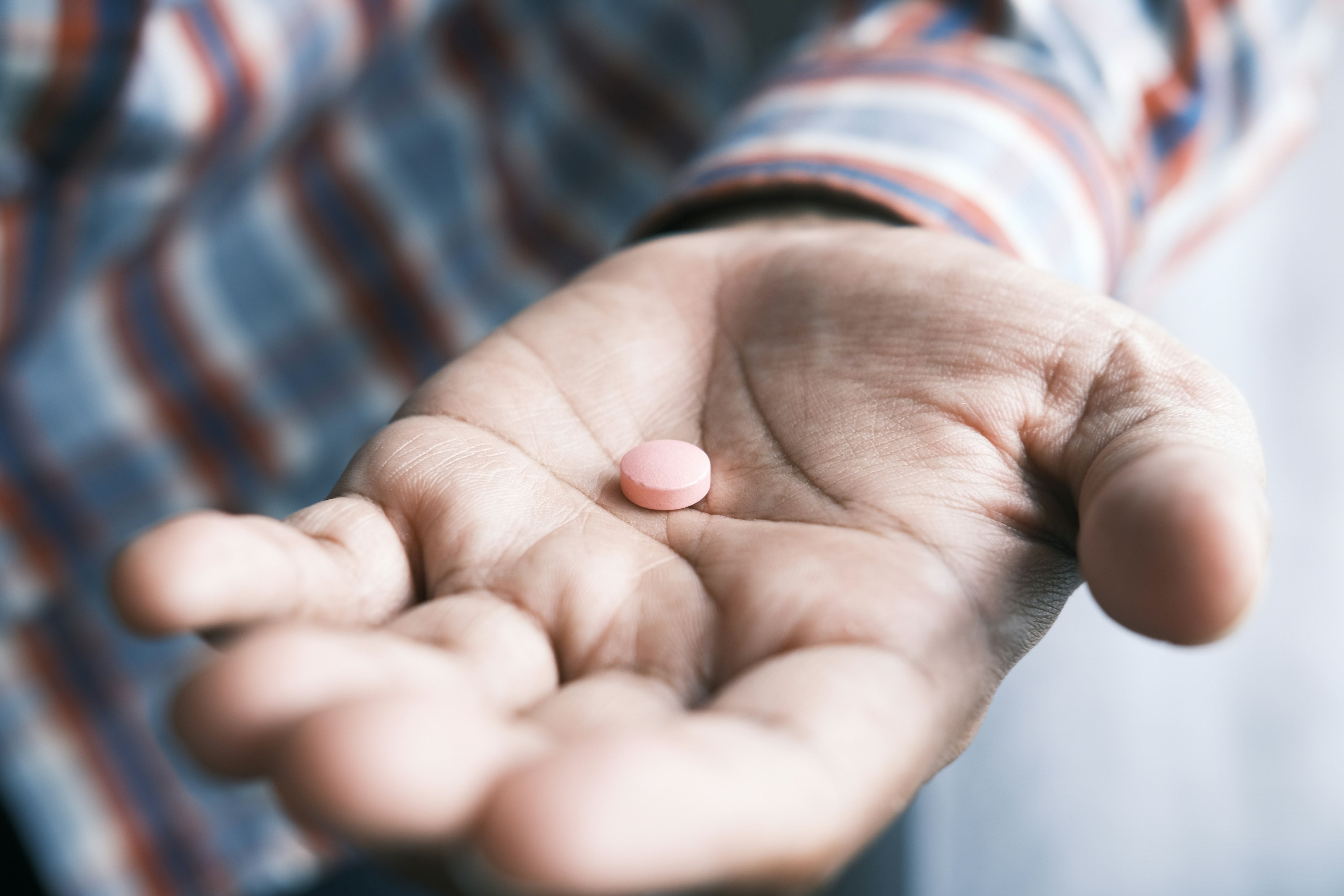 a close up of a hand with a pill